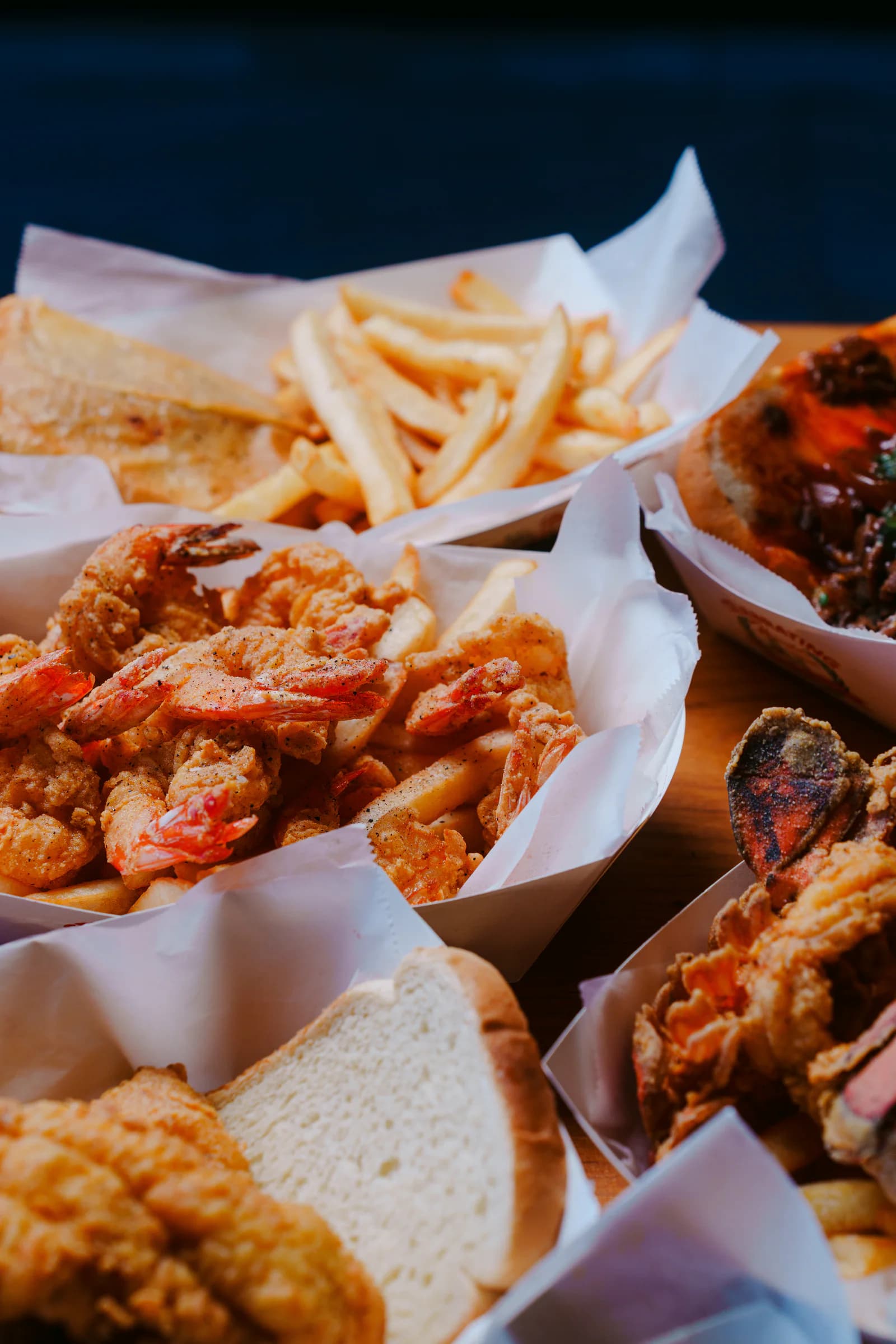 A table filled with Harold's fried shrimp, chicken, fries, and bread