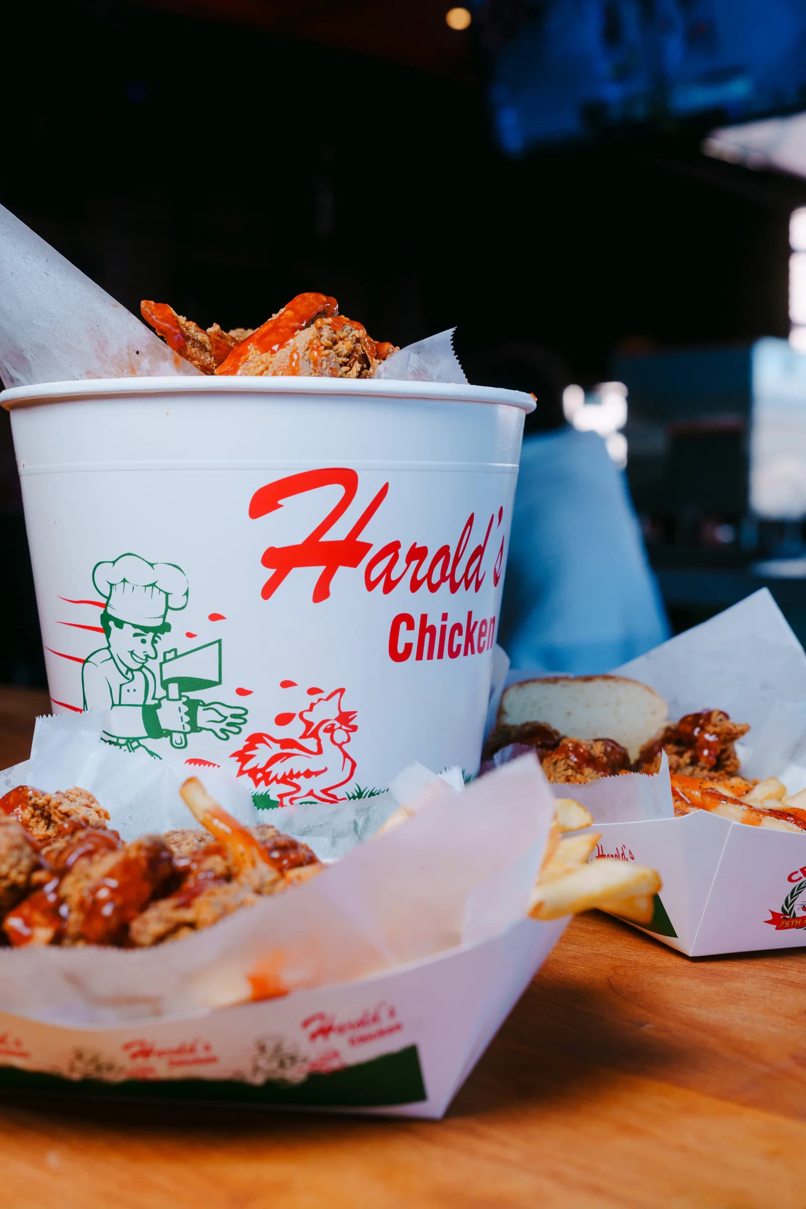 Harold's signature chicken bucket surrounded by baskets of food
